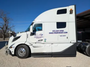 Semi-truck cut vinyl lettering with company name, phone number, and website for Russell Marine Transport in Van Alstyne, Texas