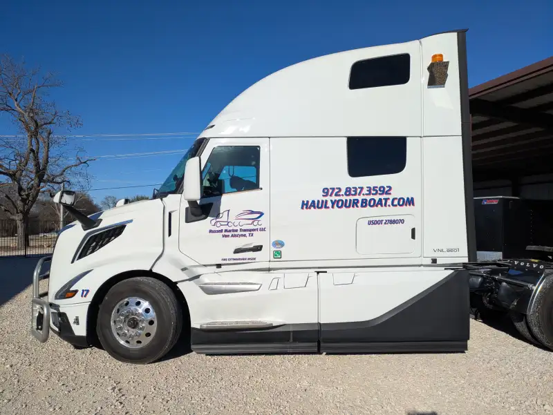 Semi-truck cut vinyl lettering with company name, phone number, and website for Russell Marine Transport in Van Alstyne, Texas