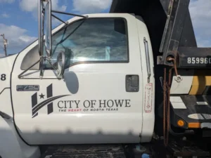 Cut vinyl fleet lettering with City of Howe logo and tagline on a municipal truck door in North Texas