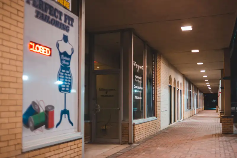 Retail storefront with window graphics promoting a seasonal sale in North Texas